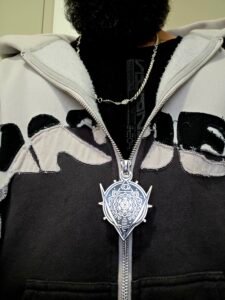 ZipDrip crest zipper pull on a black and white hoodie